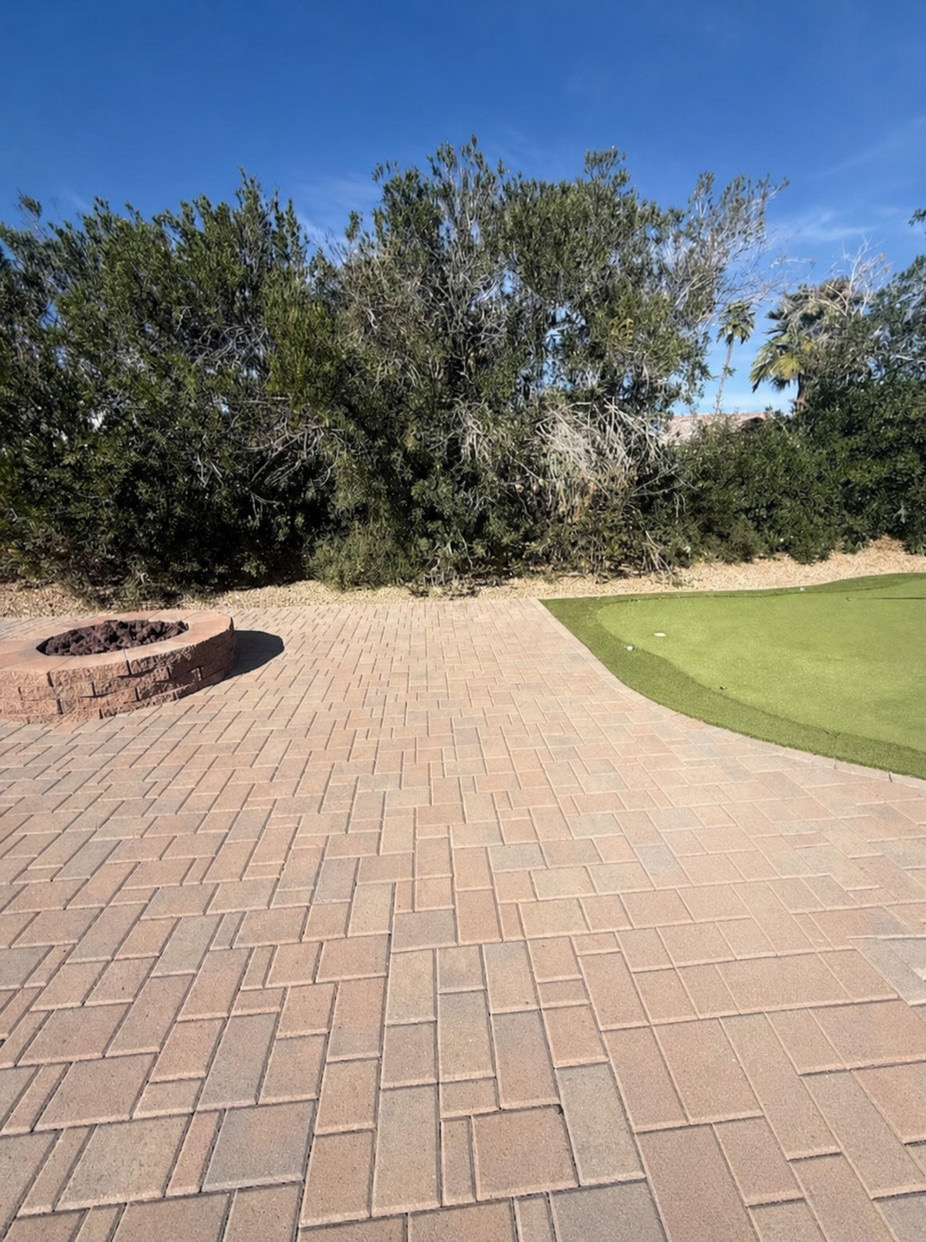 Travertine paver patio with fire pit and putting green by Turfli
